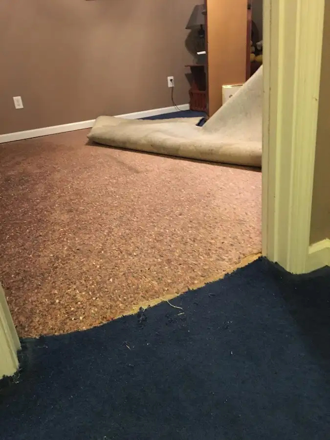 Carpet pad removal revealing water damage during Water Mitigation Services in Fort Walton Beach